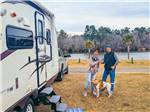A couple and dog in front of their trailer at BELLS MARINA RV RESORT - thumbnail