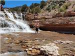 A man standing in the Toquerville Falls nearby at SETTLERS JUNCTION RV PARK - thumbnail