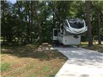 A fifth wheel trailer parked in a concrete site at TWO CREEKS CROSSING RV RESORT - thumbnail