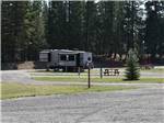 A gravel road leading to RV spots at WHISPERING PINES RV PARK - thumbnail