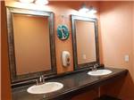 Two bathroom sinks with large mirrors at SEA GRASS RV RESORT - thumbnail