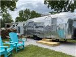 Two blue chairs in front of an Airstream at DANCING FIRE GLAMPING AND RV RESORT - thumbnail