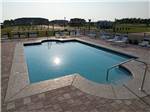 Swimming pool with lounge chairs at GRAND RIVIERA RV RESORT - thumbnail