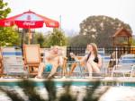 A couple sitting next to the pool at CAMP LANDA RV RESORT - thumbnail