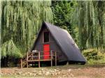 An A-shaped cabin rental with a red door at THREE RIVERS RESORT - thumbnail
