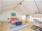 Bunk beds and a bed inside a glamping tent at ROARING RIVER HILLS CAMPGROUND AND CABINS - thumbnail