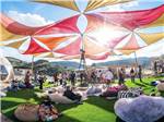People sitting under a colorful umbrella shade and talking at DEANZA SPRINGS RESORT - thumbnail