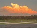 The sun shining bright behind the clouds over the RV sites at SUN CITY RV PARK - thumbnail