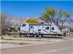 A travel trailer parked in a paved site at ESQUIRE ESTATES MH & RV PARK - thumbnail