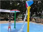 A boy playing in the splash pad at BOTEL CAMPGROUND - thumbnail