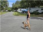 A lady walking with her dog at COOPER LAKE RV COMMUNITY - thumbnail