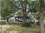 A Class C trailer parked under trees at COOPER LAKE RV COMMUNITY - thumbnail