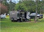 A travel trailer in a grassy site at HEAVENLY WATERS RV PARK - thumbnail