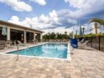 Lounge chairs in the swimming pool area at SANTA FE PALMS RV RESORT - thumbnail