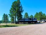 Large fifth-wheel trailer and motorcycles parked at site at PINE HAVEN VENUE & LODGING - thumbnail