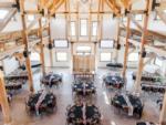 View of the rec hall with tables set for an event at PINE HAVEN VENUE & LODGING - thumbnail