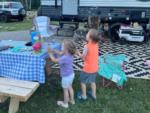 Kids blowing bubbles at their site at THE LANDING STRIP CAMPGROUND - thumbnail