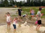 Kids playing in muddy water at THE LANDING STRIP CAMPGROUND - thumbnail