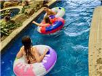 Three kids in inner tubes in the lazy river at THE RV PARK 7 CLANS FIRST COUNCIL - thumbnail