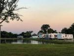 RV sites surround the pond at sunset at The Bend RV Park - thumbnail