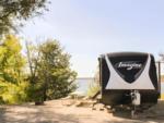An RV parked in a site by the river - thumbnail