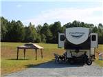A fifth wheel and motorcycle at a site - thumbnail