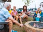 Group of people gathering around a fire pit at OCEANS RV RESORT - thumbnail