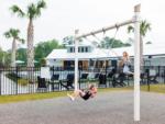 Two girls playing on the swings at OCEANS RV RESORT - thumbnail