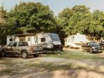 Trailers parked near pickup trucks at Country Dream RV Park - thumbnail