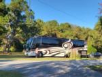 Side view of RV parked in camp site at HITCHINPOST RV PARK AND CAMPGROUND - thumbnail