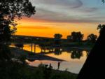 People fishing along river at sunset at RIVERSHIRE RV RESORT & CAMPING - thumbnail