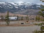 Vintage trailer with snow-capped hills in the distance at GRAND BUFFALO RV RESORT - thumbnail