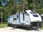 Travel trailer parked on paved site at The Retreat RV Resort & Camping - thumbnail