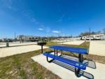 A blue picnic bench and bbq pit at a site at NEW CANEY RV PARK - thumbnail