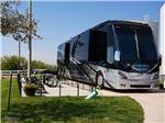 A Class A motorhome in a paved site with patio at Crossroads Luxury RV Park - thumbnail