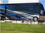 Large motorhome in a paved site with picnic table at Crossroads Luxury RV Park - thumbnail