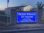 The front entrance sign lit up at night at DESERT SPRINGS RV RESORT - thumbnail