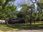 A trailer parked in a shady RV site at BRAZOS RIVER HIDEOUT - thumbnail