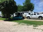 A car and truck parked next to a trailer at BROKEN SPOKE RV - thumbnail