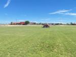 A tent pitched in an open grassy field at SILVER WIND RV PARK AND CABINS - thumbnail