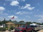 A truck and Airstream trailer passing the office at TIMBER RIDGE RV PARK - thumbnail