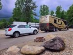 A car and Motorhome parked in a paved site at SMOKY MOUNTAIN PREMIUM CAMPING - thumbnail