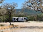 View of green hills beyond a fifth-wheel at LOST MAPLES RV AND CAMPING - thumbnail