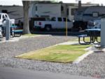 Grassy area and picnic table on a site at ROSEDALE VILLAGE RV PARK - thumbnail