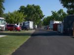 Paved road lined with grass and RVs at ROSEDALE VILLAGE RV PARK - thumbnail