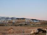 Dirt sites in front of snow topped hills at Capitol Reef RV Park & Glamping - thumbnail