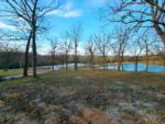 Grass area with lake view at site Mimosa Place RV Park - thumbnail
