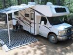 Parked RV with covered patio at site Harmony Ridge RV Park - thumbnail