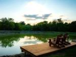 Pond with deck and chairs at SILO CREEK RV RESORT - thumbnail