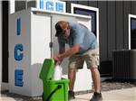 A person putting a bag of ice in an ice chest - thumbnail